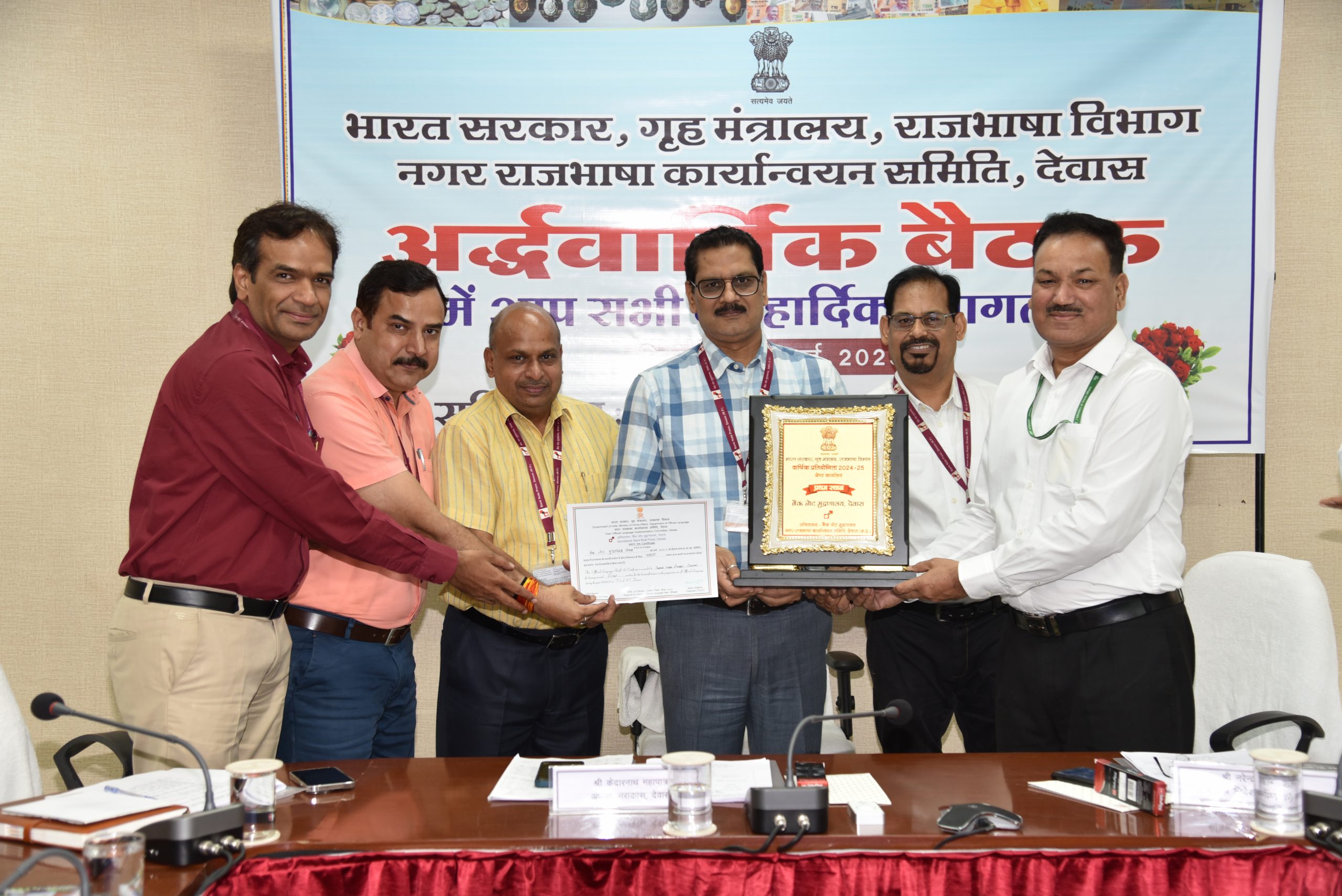 नगर राजभाषा कार्यान्वयन समिति, देवास में राजभाषा में सर्वोत्कृष्ट कार्यान्वयन हेतु बैंक नोट मुद्रणालय, देवास को उप निदेशक (मध्यक्षेत्र) क्षेत्रीय कार्यान्वयन कार्यालय, राजभाषा विभाग, भोपाल द्वारा दिनांकः 24 जुलाई, 2025 को महाप्रबंधक एवं विभागाध्यक्ष, बैंक नोट मुद्रणालय को नराकास, देवास राजभाषा चल शील्ड एवं प्रमाण पत्र से सम्मानित किया गया।
